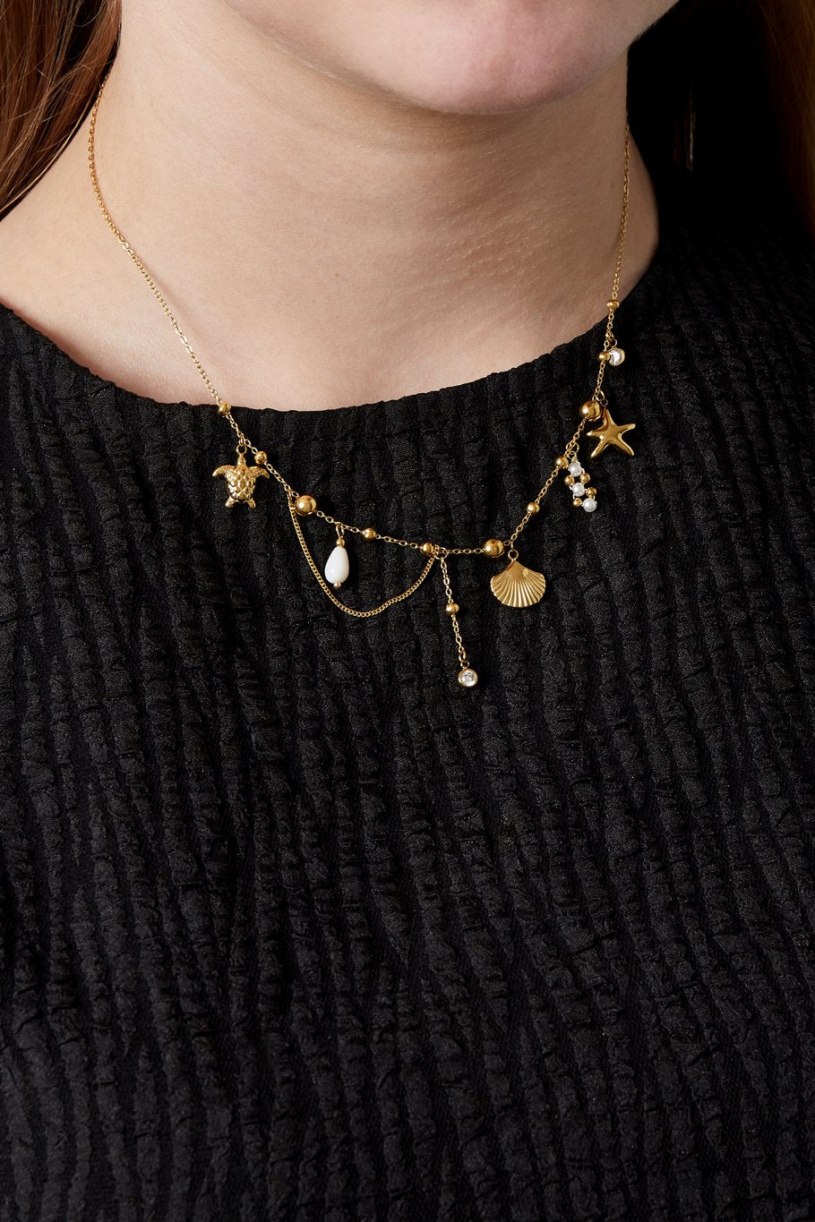Edelstahlhalskette in gold mit Schildkröten-, Muschel- und Seesternanhänger, sowie künstliche Perlen und Zirkon-Steinen, 39+5cm lang.