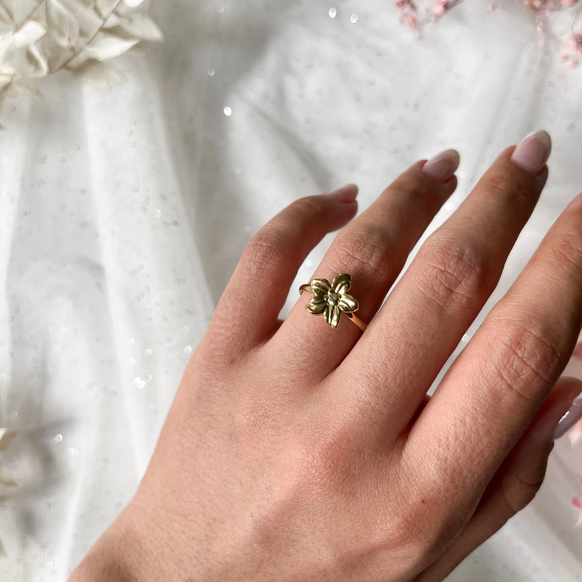 Edelstahlring in gold mit Blume und Zirkon-Stein, größenverstellbar.
