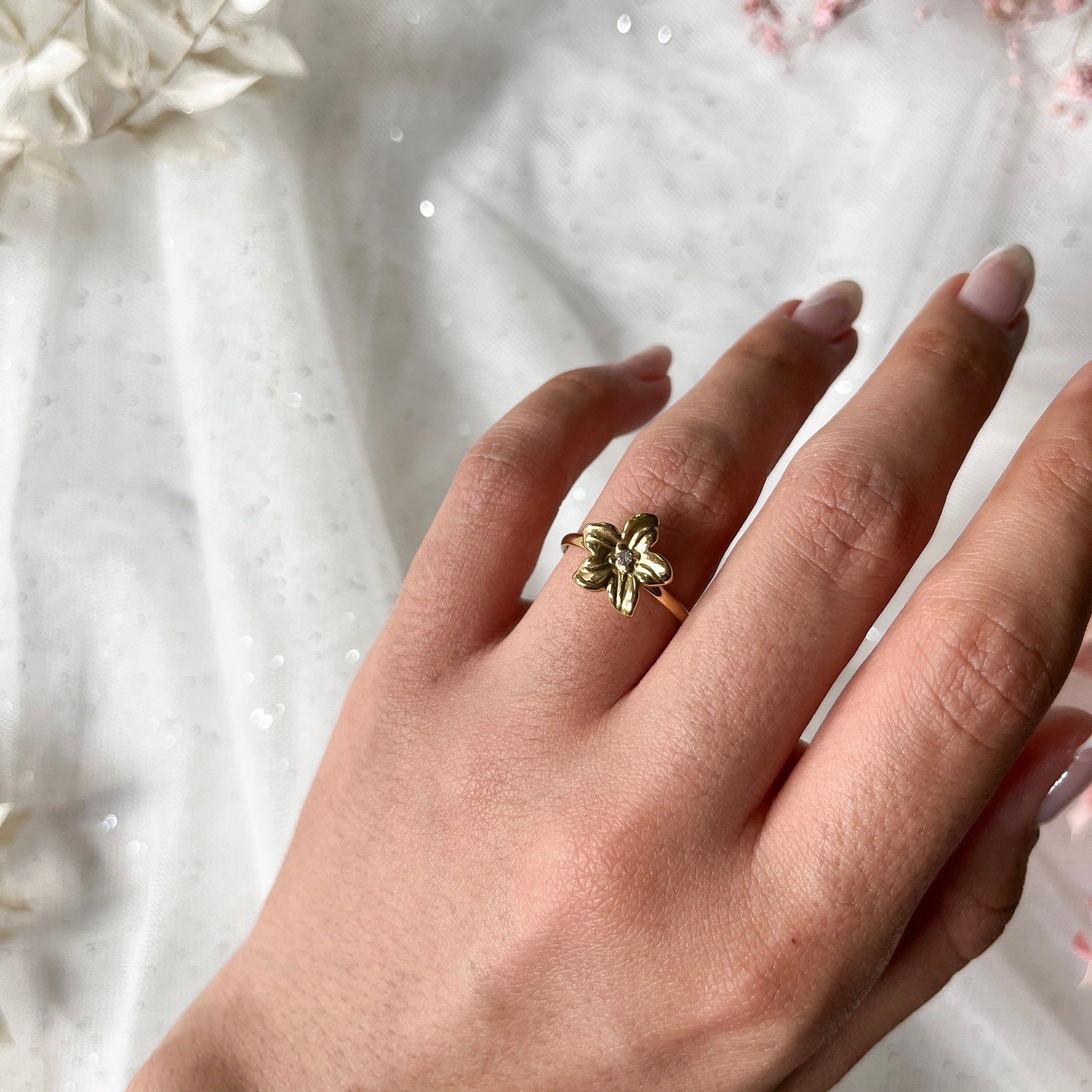 Edelstahlring in gold mit Blume und Zirkon-Stein, größenverstellbar.
