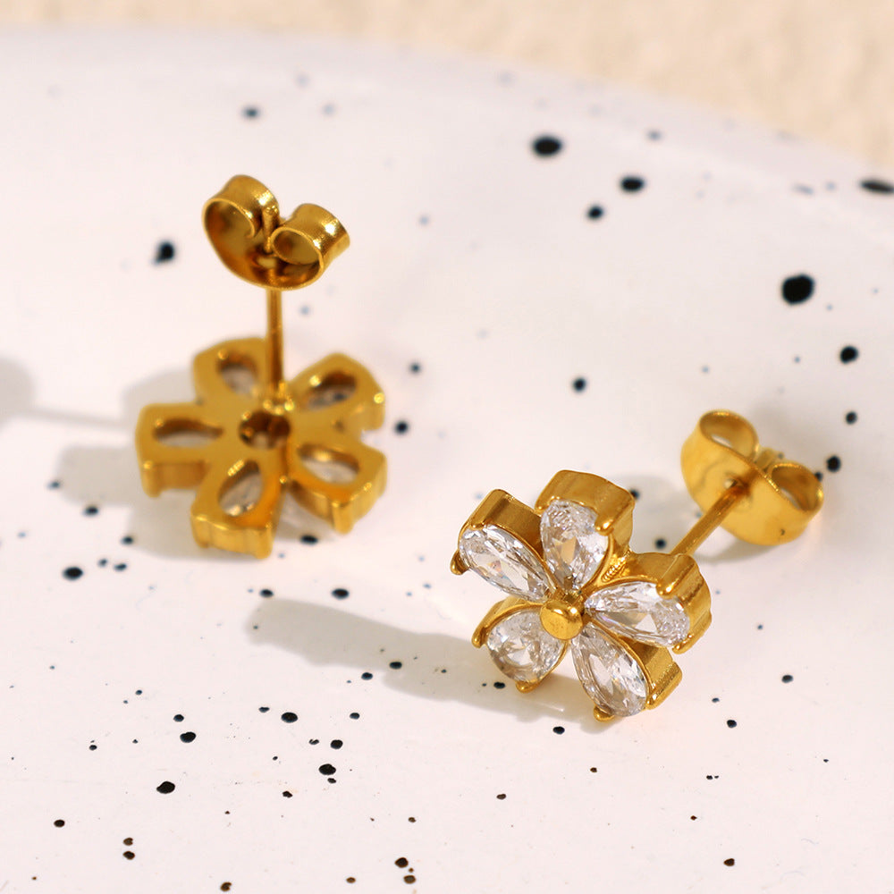 Goldene Blüten-Ohrstecker aus Edelstahl mit funkelnden Zirkonia-Blütenblättern – feminin, wasserfest und nickelfrei.
