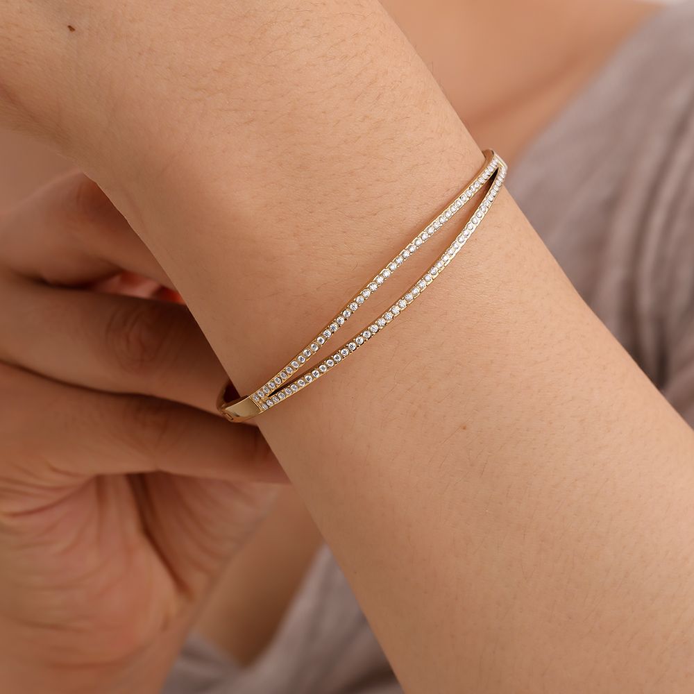 Goldener Armreif mit überkreuzten Zirkonia-Linien – 14K vergoldeter Edelstahl.