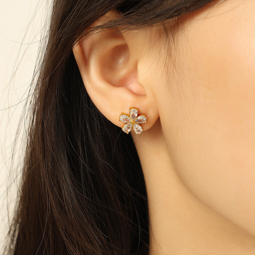 Goldene Blüten-Ohrstecker aus Edelstahl mit funkelnden Zirkonia-Blütenblättern – feminin, wasserfest und nickelfrei.